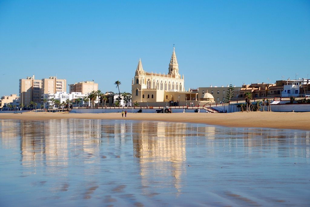 Playa de Regla en Chipiona con el Santuario de Regla al fondo.